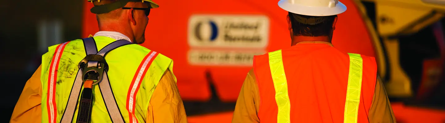 two men in ppe near boom lift