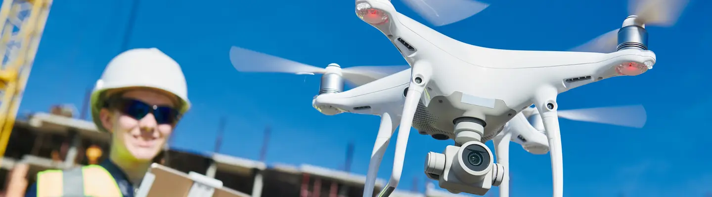 female drone pilot operating uav on construction site