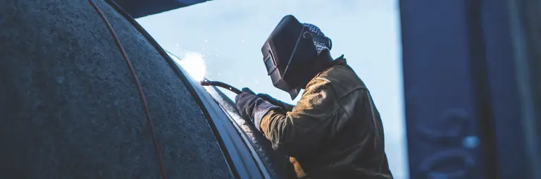 welder in trench