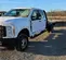 Angled front-right view of a white Ford F-350 Super Duty dually pickup truck with a flatbed.