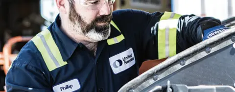 man wearing united rentals shirt working on equipment