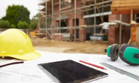 tablet and hard hat on construction site outside