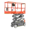 Side angled view of a retracted orange Skyjack scissor lift with safety rails.