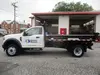 White Ford single-axle dump truck parked outside outside of a garage