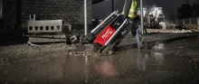 Worker pulling a light tower in the rain
