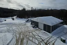 Large construction tent in a snowy outdoor environment, showcasing its durable vinyl cover and climate-controlled design.